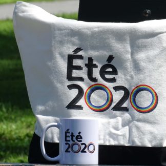 Cette image présente notre tasse et notre sac Été 2020 sur un banc de parc.